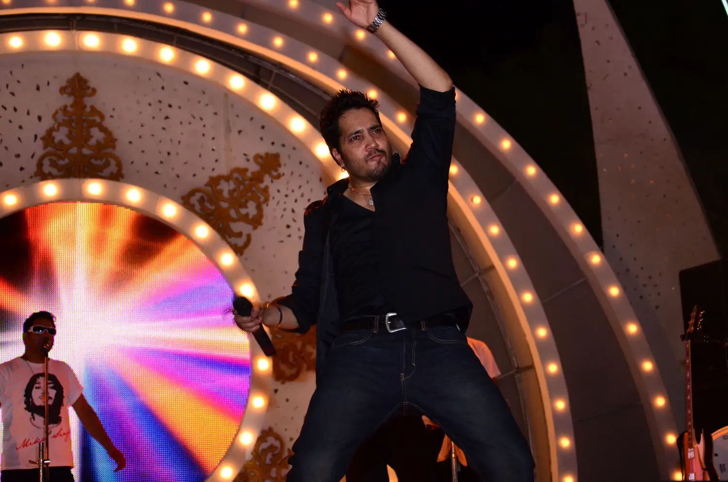 Balloon arch in orange, black, and white colors framing an ITT logo board lit with warm lights